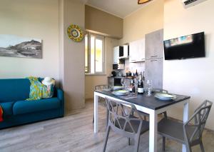 卡普多兰多Capo d'Orlando Apartments - Doria 52的客厅配有桌子和蓝色沙发