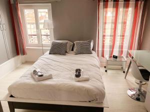 克莱蒙费朗DUPLEX - TERRASSE 2 CHAMBRES CENTRE-VILLE JAUDE的一间卧室配有一张大床,上面有两双鞋