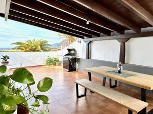 阿尔卡拉Alcalá Retreat: Ocean View & Modern Comfort的一个带木桌和烧烤架的庭院