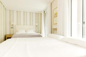 萨拉戈萨索斯酒店的带窗户的客房内的2张白色床
