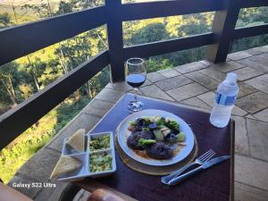 伊塔蒂亚亚维斯塔林达酒店的一张桌子,上面放着一盘食物和一杯葡萄酒