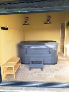 MollégèsMaison Provençale Spa Sauna Piscine的带长凳的客房内的热水浴池