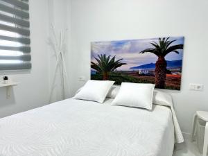 阿尔卡拉Alcalá Retreat: Ocean View & Modern Comfort的一间卧室配有白色的床,两棵棕榈树