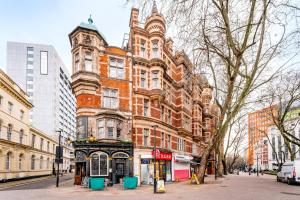 伦敦Welcome London - New Oxford Street的城市街道上一座大型砖砌建筑