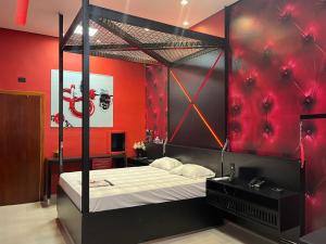 孔塔任Motel Stilo - Adults Only的一间卧室配有一张带红色墙壁的天蓬床