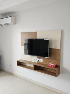 新德里Kali Bari View by Maple Key Stays - 3BHK & Terrace的客厅的墙上设有平面电视