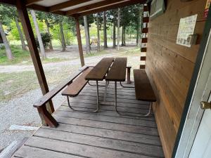 那须盐原市Nasu Takahara Auto Campsite - Vacation STAY 42066v的木门廊上的野餐桌和长椅