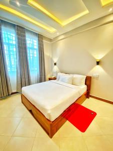 阿鲁沙Nexa Hotel的卧室配有一张白色大床和红色地毯