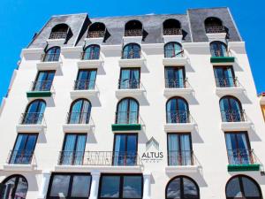 拉巴斯Altus Express Hotel的白色的建筑,设有窗户和阳台