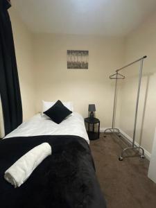 莱斯特Spacious 4-bed House in Leicester的卧室配有黑白床和灯