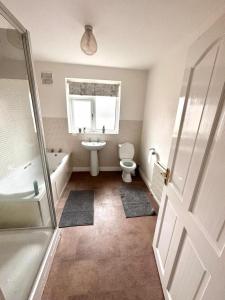 莱斯特Spacious 4-bed House in Leicester的浴室配有卫生间、浴缸和水槽。
