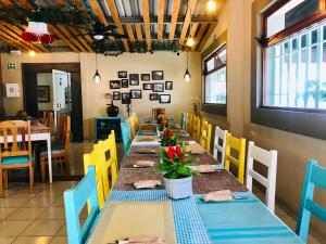 科米坦德多明格斯Hotel Casa Caelum的用餐室配有长桌和黄色及蓝色的椅子