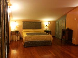 Belforte del ChientiB&B Antegiano的一间卧室设有一张大床,铺有木地板