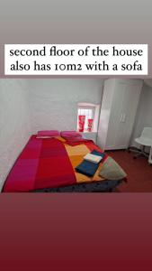 阿洛拉Alora Sweet Home的一间卧室配有一张带五颜六色棉被的床