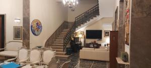 莱切Dimora Charleston Lecce parcheggio privato in loco gratis的客厅设有楼梯、椅子和电视