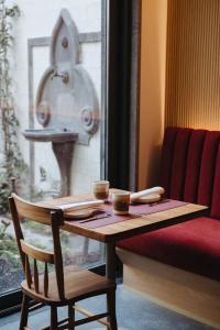 蓬塔德尔加达NINE DOTS Azorean Art Boutique Hotel的一张木桌和椅子,上面有两杯