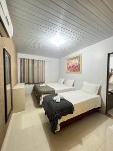 MateirosPOUSADA CABANA DO PARQUE的酒店客房设有两张床和窗户。