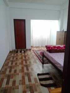 西里古里Areca Holiday Apartment的一间设有床铺和窗户的房间