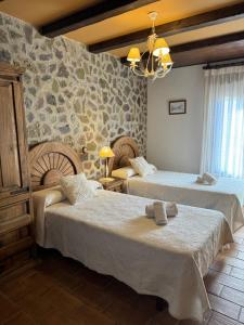 贝拉德蒙凯奥El Rincon del Moncayo的一间卧室设有两张床和石墙