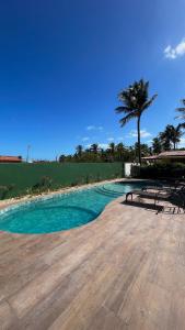 巴拉格兰德Pousada Lá em Casa的棕榈树和蓝色海水游泳池