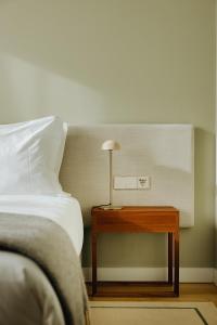 蓬塔德尔加达NINE DOTS Azorean Art Boutique Hotel的一间卧室配有一张床和一张带台灯的桌子