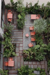 蓬塔德尔加达NINE DOTS Azorean Art Boutique Hotel的花园的顶部景色,花园内种有椅子和植物