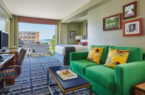 麦迪逊麦迪逊毕业生酒店的酒店客房带绿色的沙发和一张床