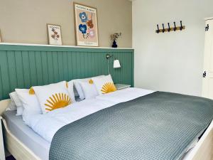 费马恩Kajüthus Apartment 1的一张配有白色和黄色枕头的大床