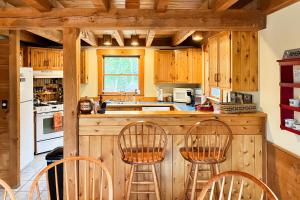 East BurkePeaceful Mountain Delight的厨房配有木制橱柜和带椅子的柜台。