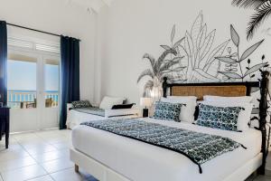 圣弗朗索瓦阿茂多酒店的卧室配有两张床,墙上挂有壁画