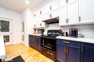 埃德蒙顿The Obsolete Suite - King Bed - Fireplace - Pet Friendly的厨房配有蓝色橱柜和炉灶烤箱。