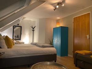阿纳姆Bed and breakfast Carma Arnhem的一间卧室配有一张床和一个蓝色的橱柜