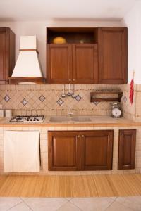 莱万佐Casa del Nostromo的厨房配有木制橱柜和炉灶烤箱。