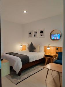 乔卢拉CHOLULA SUITES的一间卧室配有一张大床和一张蓝色椅子