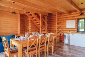 ZalesieZalesie - wyjątkowe domki nad jeziorem的小屋内带桌椅的用餐室