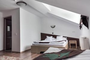 沃拉内特Casa Bradul Voronet的卧室配有2张床和白色墙壁