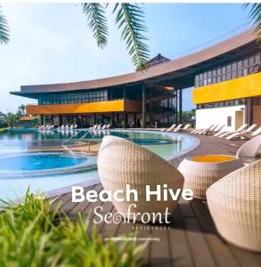 八打雁Beach Hive Seafront Residences Villa in San Juan Batangas的一个带椅子和游泳池的度假村