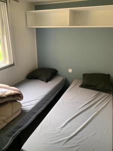 乌伊斯特勒昂Mobil-home Ouistreham的带窗户的客房内设有两张单人床。