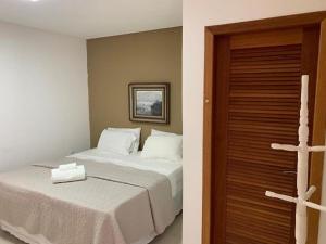 瓜拉派瑞Espaço Hale Kai的卧室配有白色的床和木门