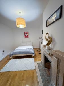 ColindaleLA CASITA的一间卧室配有一张床和一个壁炉