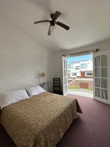 埃斯特角城Bagu Villa de Mar的一间卧室配有一张床和吊扇