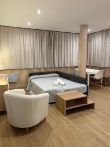 塞拉内华达Primavera Premium Sierra Nevada 4的一间卧室配有一张床、一把椅子和一张桌子