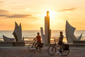 CommesMaison renovee en pierres séjour spacieux avec jardin et terrasse aménagée près Omaha beach & Bayeux à 5mn de la mer tous commerces的日落时分在海滩上骑两辆自行车