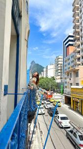 里约热内卢HMG Rio Suítes的站在建筑物阳台上的妇女