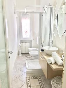 萨沃纳Casa di Riccardo的白色浴室设有2个水槽和2个卫生间