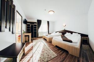 沃拉内特Casa Bradul Voronet的酒店客房设有两张床和一张桌子。
