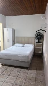 伊瓜苏Studio Iguassu falls GARAGEM COZINHA E AR的卧室设有白色的床和木制天花板。
