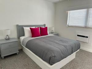 圣徒皮特海滩EBBTIDE INN的一间卧室配有一张大床和两个红色枕头