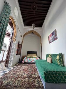 拉巴特Riad Palais D'Or的客厅配有绿色沙发和床。