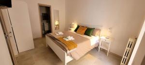 孔韦尔萨诺Adalù apartments的一间卧室配有一张大床,提供黄色和绿色的枕头